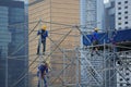 Unidentified workers are scaffolding on the site in the city surrounding by skyscrapers in Central