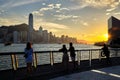 Tourists enjoy sightseeing of Victoria Harbour at Avenue of stars at sunset.