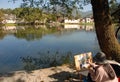 Hongcun Ancient Town in Anhui Province, China. An artist sits by Nanhu Lake painting the buildings and trees