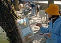 Hongcun Ancient Town in Anhui Province, China. An artist stands by Nanhu Lake painting the buildings and trees