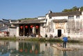 Hongcun Ancient Town in Anhui Province, China. Lexu Hall, old buildings and a man on a raft on Moon Pond