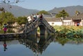 Hongcun Ancient Town in Anhui Province, China. The stone bridge crossing Nanhu Lake with people taking photographs
