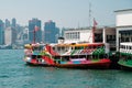 Colorful Star Ferry boat on Tsim Sha Tsui Star Ferry Pier and HongKong Island skyline background