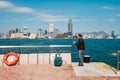 Fisher man with fishing rod on coast with HongKong skyline