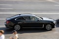 Hongqi H9 at the city road in motion. Black full-size luxury car driving along the street in city, side view. Accelerating with Royalty Free Stock Photo