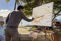 Honolulu, Hawaii - Nov 6, 2021-Man demonstrates painting on a beach en plein air