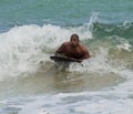 Honolulu, Hawaii - Nov 6, 2021-Man rides shallow surf on a bookey board