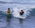 Honolulu, Hawaii - Nov 6, 2021-Young boys play on their boogey boards in the surf Royalty Free Stock Photo