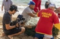 Honolulu, Hawaii, USA - 2022-08-20 - Shaka Filming Hukilau - A videographer films people preparing the net for the ocean Royalty Free Stock Photo