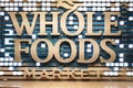 Amazon subsidiary Whole Foods Market decorative logo design at entrance of grocery store.