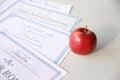 A honor roll recognition, certificate of achievement and high school diploma lies on table with red apple. Education documents Royalty Free Stock Photo