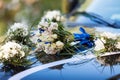 The hood of a black car is decorated with a bouquet of flowers in a wedding style. Royalty Free Stock Photo