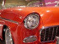 The hood, headlight and front wheel of the vintage car. Chrome grille and bumper. Oldtimer in the garage. Royalty Free Stock Photo