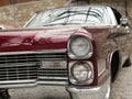 The hood, headlight and front wheel of the vintage car. Chrome grille and bumper. Oldtimer in the garage. Royalty Free Stock Photo