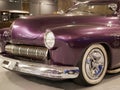 The hood, headlight and front wheel of the vintage car are purple. Chrome grille and bumper. Oldtimer in the garage. Royalty Free Stock Photo