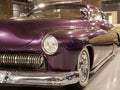 The hood, headlight and front wheel of the vintage car are purple. Chrome grille and bumper. Oldtimer in the garage. Royalty Free Stock Photo