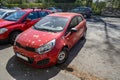 Hood and windshield of red car smudged by bird dropping and birch tree farina