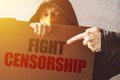 Hooded activist protestor holding Fight censorship protest sign Royalty Free Stock Photo