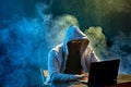 Hooded computer hacker stealing information with laptop Royalty Free Stock Photo