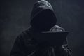 Hooded computer hacker using digital tablet