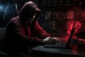 Hooded computer hacker using laptop in dark room. Cybercrime concept, hacker without a face is trying to steal cryptocurrency
