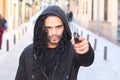 Hooded ethnic criminal holding a gun outdoors Royalty Free Stock Photo