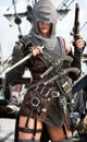 Hooded female pirate assassin poses with her arsenal of weapons on the deck or her ship.