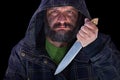 Hooded frightening man with dirty face and big knife Royalty Free Stock Photo