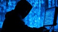 Hooded hacker at computer in cyber matrix environment