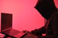 Hooded hacker in front of a computer for organizing massive data breach attack around the world Royalty Free Stock Photo