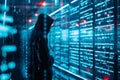 A hooded hacker looking at data server storage. Cybersecurity, stolen data, privacy. Copy space.