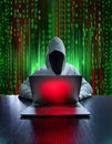 A hooded hacker working on a laptop with a red screen, surrounded by green binary code