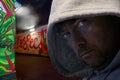 Hooded man in graffiti decorated subway