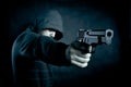 Hooded man with a gun in the dark Royalty Free Stock Photo