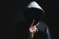 Hooded man making silence gesture Royalty Free Stock Photo