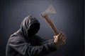 Hooded man with an axe in the dark Royalty Free Stock Photo