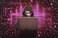 Hooded man wearing mask typing on laptop Royalty Free Stock Photo