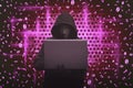 Hooded man wearing mask typing on laptop Royalty Free Stock Photo