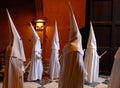 Hooded penitents leaving the church before the start of an easter holy week procession in mallorca