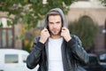 Hooded and protected. Handsome man unshaven face and stylish hair. Caucasian man urban background. Bearded man leather Royalty Free Stock Photo