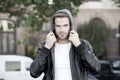 Hooded and protected. Handsome man unshaven face and stylish hair. Caucasian man urban background. Bearded man leather Royalty Free Stock Photo