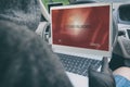 Hooded thief tries to break the car`s security systems with laptop Royalty Free Stock Photo