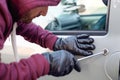 Hooded thief trying to open a car door lock steal Royalty Free Stock Photo