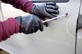 Hooded thief trying to open a car Royalty Free Stock Photo