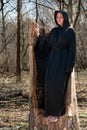 Hooded Woman in black robes deep in the Forest. Witches. Halloween and Gothic concept. Witchcraft and magic. Scary Royalty Free Stock Photo