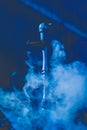 Hookah head, clay bowl and pipe, smoking object in smoke and blue light, relaxation atmosphere