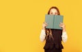 Hooked on book. Small child cover face with book. Little girl read book yellow background. Cute bookworm. Adorable