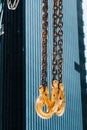 The hooks of the mobile crane near the glass of high buildings.Lots of hooks hanging from chains suspended from a crane