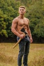 Hooligan man. sexy macho bare torso ax. brutal and attractive male in wood. bodybuilder show his muscles. power and