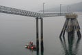 Hoonah, Alaska: Two workmen in a small boat under an unoccupied cruise ship dock Royalty Free Stock Photo